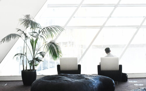 Mann sitzt in einer hellen Lounge