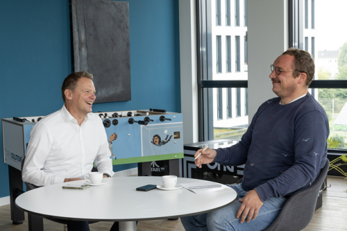 Interview digitales Management in der Wohnungswirtschaft, Jens und Christian Westphal sitzen im Aufenthaltsraum im Büro